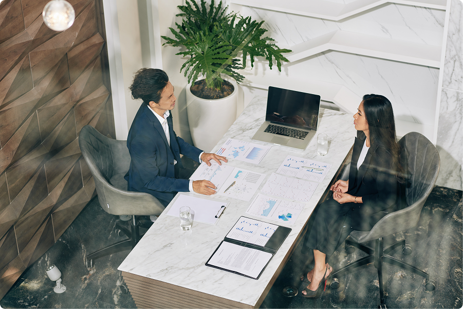 portrait-of-young-asian-financier-worki-2025-03-25-09-21-04-utc 1 perennial accounting;man and woman sitting across each other in an office